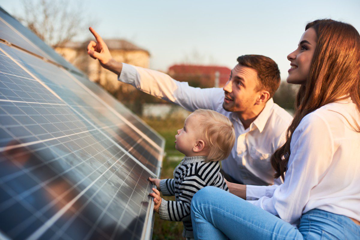 Family exploring solar panels together outside.