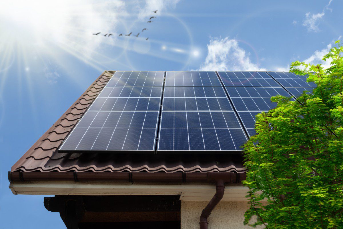 Solar panels on roof under clear sky.