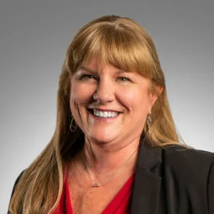 tm3-300x300 Smiling woman with long hair and blazer.